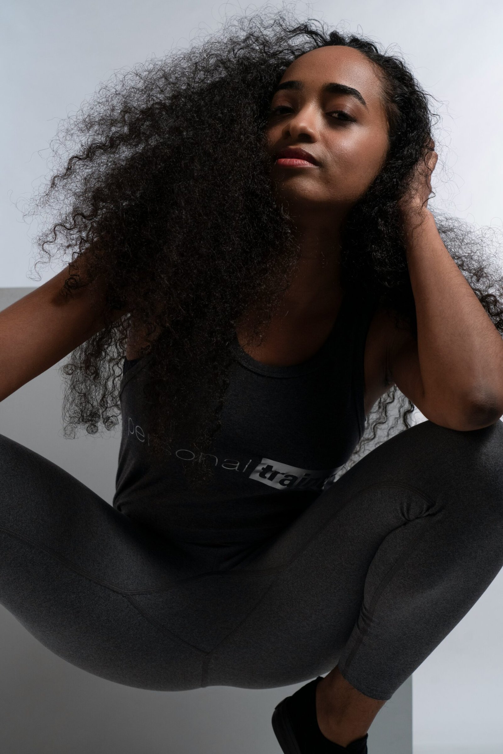 a woman sitting on the floor with her hands on her head